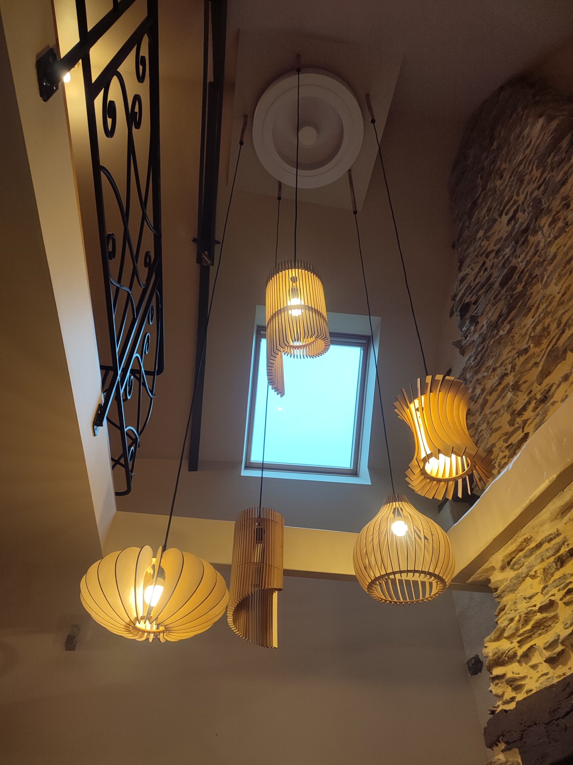 Suspensions en bois sculpté installées par un menuisier en Bretagne, éclairage artisanal et design naturel.