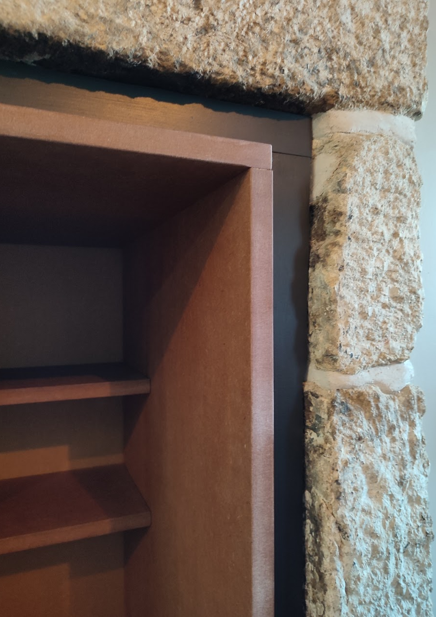 Niche en bois massif intégrée dans un mur en pierre, réalisation de menuiserie en Bretagne.